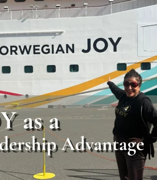 Dorice Horenstein standing on a dock, smiling and pointing proudly at the "Norwegian JOY" ship name to visualize the blog's core message of utilizing joy as a leadership advantage for high-performing, mentally fit teams.