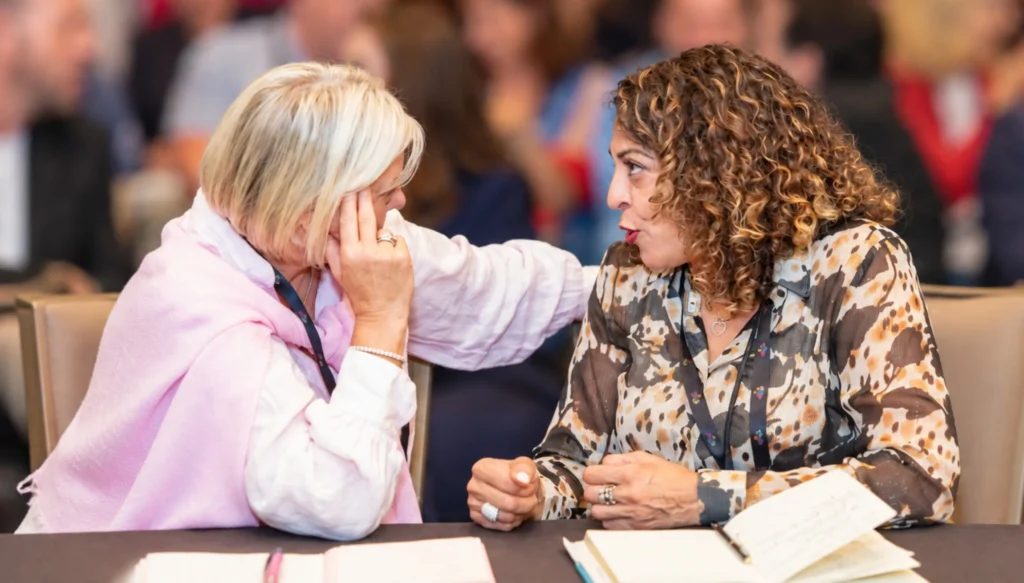 Executive Leadership Coach Dorice Horenstein having a meaningful conversation with an attendee during an interactive leadership event.