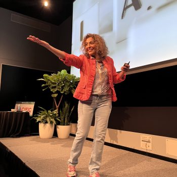 Dorice Horenstein delivering a keynote speech on stage, sharing strategies for building resilient teams and effective leadership.