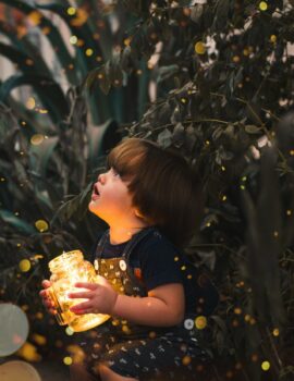 child-holding-clear-glass-jar-with-yellow-light-2026960